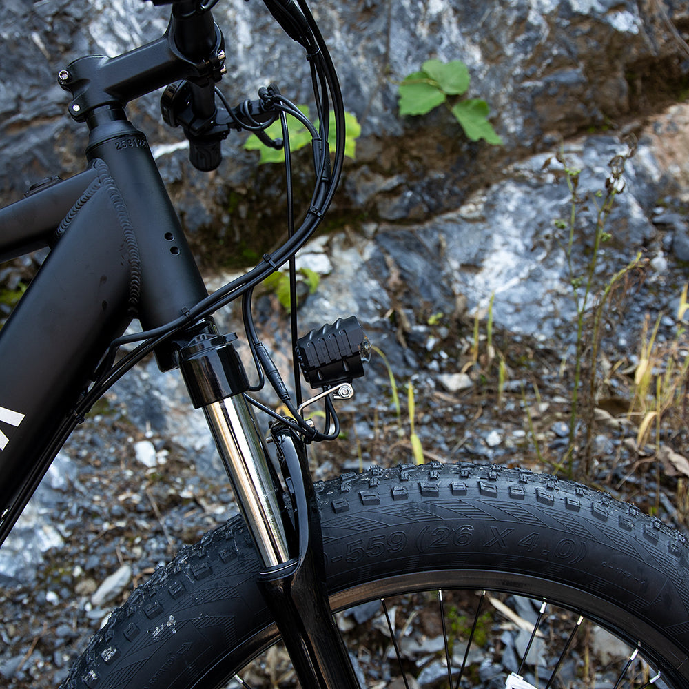 Close-up of a black bicycle on a rocky terrain