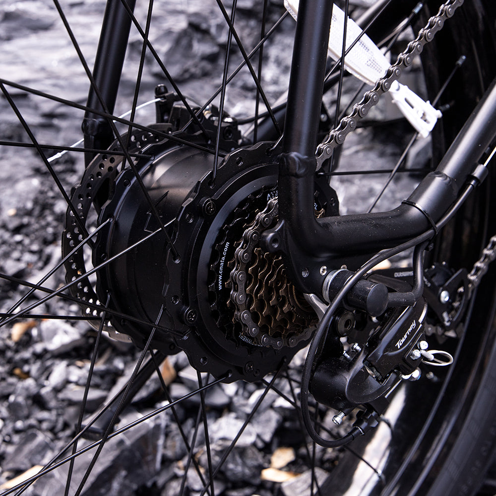 Close-up of a bicycle's gear system on a gravel surface