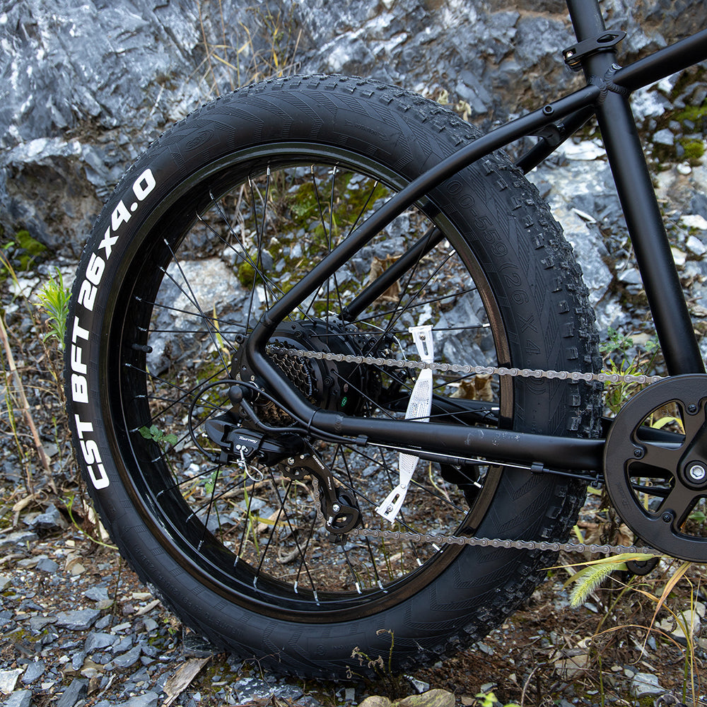 Close-up of a bicycle wheel with thick tire on a rocky ground